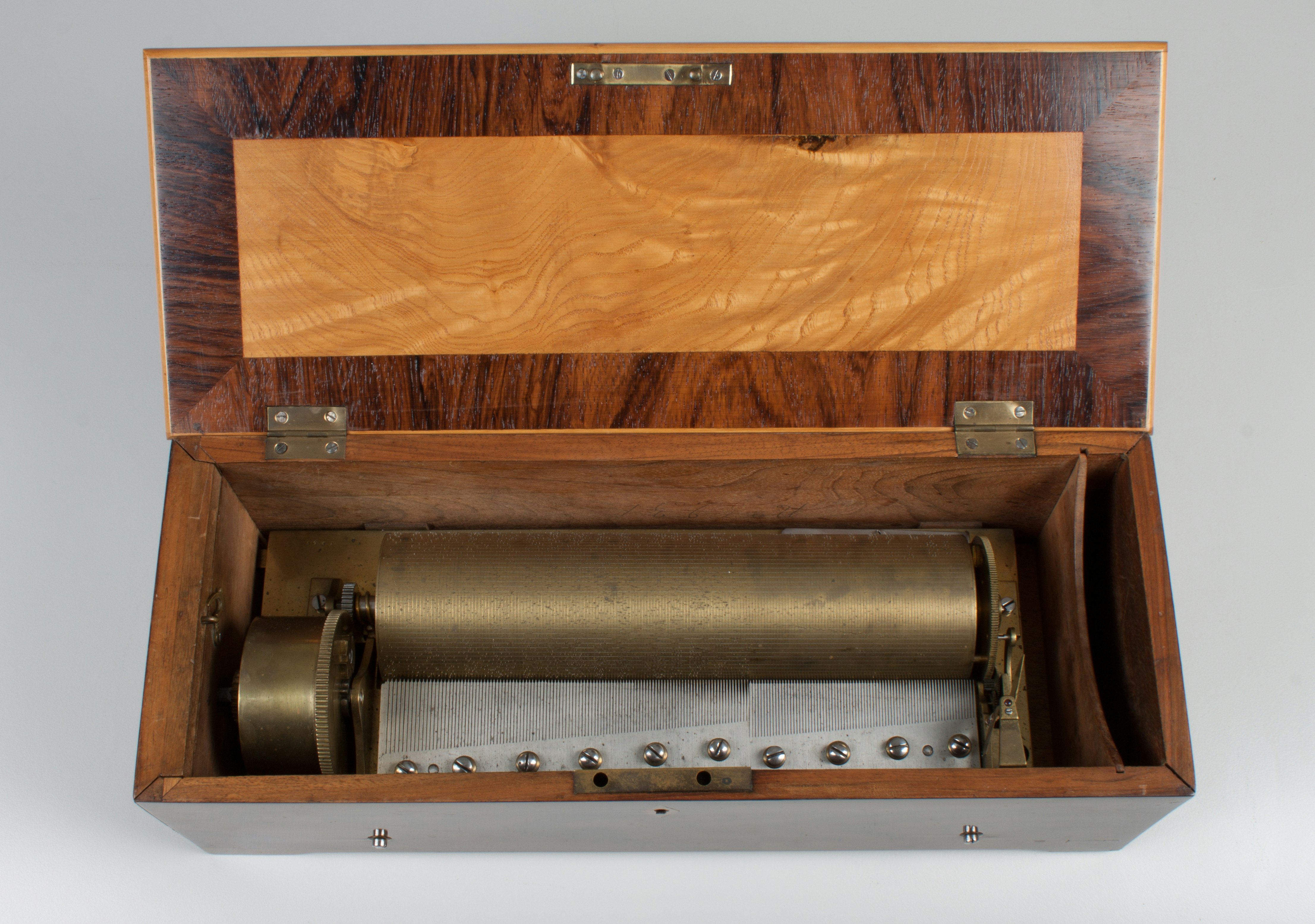 3 Musikstücke; 2 Stimmkämme: Forte-Kamm mit 113 Tönen, Piano-Kamm mit 77 Tönen. Die grafische Einteilung des Zylinderumfanges (Längslinien) deutet auf François Nicole als Hersteller hin. 42,5 x 19 x 13,5 (28) cm (L. x T. x H., ( ) H. mit geöffnetem Deckel).